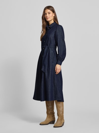Frauenmodel trägt Midikleid mit Druckknopfleiste von More & More aus dunkelblauer Baumwolle, tailliert mit Gürtel, Ganzkörperansicht von vorne.