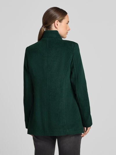 Modelka nosi kurtkę 'Jacke mit Stehkragen und Eingrifftaschen' od FUCHS SCHMITT, Mieszanka materiałów z dodatkiem wełny, linia a, stójka, listwa guzikowa, wpuszczane kieszenie, długość tyłu w rozmiarze 36: 73 cm, szerokość ramion w rozmiarze 36: 37 cm, szerokość w klatce piersiowej w rozmiarze 36: 48 cm, długość rękawów w rozmiarze 36: 64 cm, ciemnozielony kolor, gładka tekstura, widok całej sylwetki z tyłu.