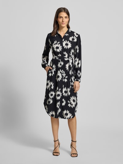 Frauenmodel trägt Midikleid mit Bindegürtel von Esprit, Reine Viskose, Gerader-Schnitt, Umlegekragen, Floraler-Allover-Print, Durchgehende-Knopfleiste, Bindegürtel, Schwarz mit weißen Blüten, Ganzkörperansicht von vorne.