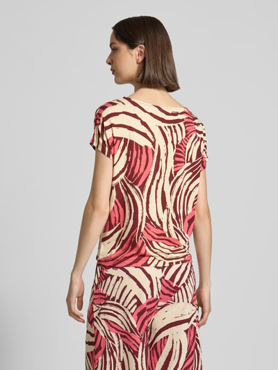 Frauenmodel trägt Relaxed Fit T-Shirt aus Viskose-Mix von s.Oliver RED LABEL mit Optik:Allover-Muster in Rot und Beige, Jersey, Ganzkörperansicht Rückansicht.