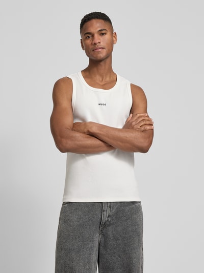 Männermodel trägt Slim Fit Tank Top aus Baumwoll-Mix Modell 'DAPOTA' von HUGO, Optik: Unifarben, Rundhals, Feinripp, Label-Applikation, Ganzkörperansicht von vorne.