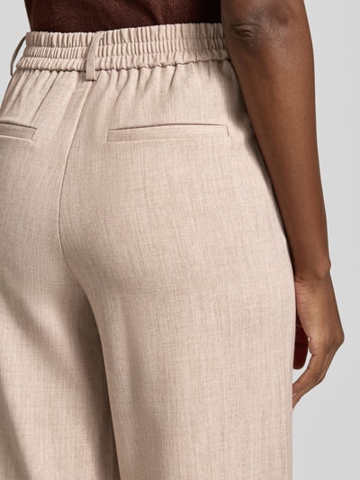 Frauenmodel trägt High Waist Hose Modell 'VARONE' von Vila in Beige mit feiner Struktur, Material-Mix mit Viskose-Anteil, Detailaufnahme Rückansicht.