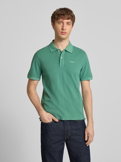 Männermodel trägt Regular Fit Poloshirt aus reiner Baumwolle Modell 'OSCAR' von Pepe Jeans, Farbe grün, Optik: Unifarben, Piqué, Nahaufnahme Oberkörper.