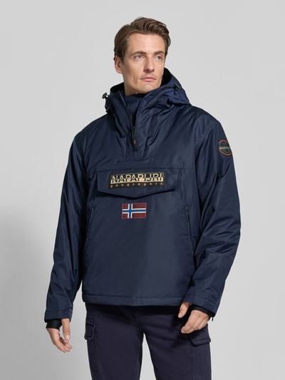 Männermodel trägt Jacke mit Kapuze und kurzem Reißverschluss von Napapijri, dunkelblau, recht model, labelpatch, Klepzak, Ganzkörperansicht von vorne. Ruglengte bij maat M 73 cm, schouderbreedte 53 cm, borstwijdte 60 cm, mouwlengte 64 cm.