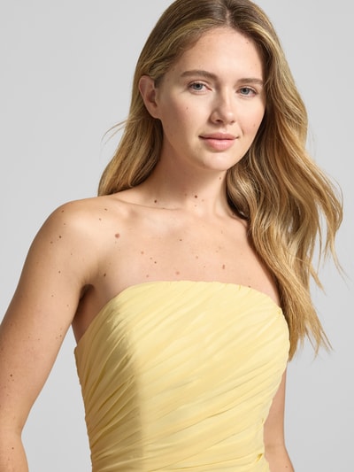 Frauenmodel trägt Slim Fit Abendkleid in Falten-Optik von Luxuar in zartem Gelb mit blickdichtem Unterrock, schulterfrei, Nahaufnahme Oberkörper.
