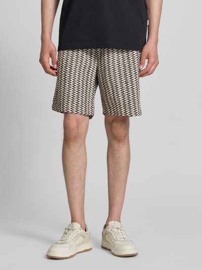 Männermodel trägt Relaxed Fit Stoffshorts aus Baumwoll-Mix von s.Oliver RED LABEL mit Strukturmuster und elastischem Bund, Nahaufnahme Oberschenkel bis Schuhe.