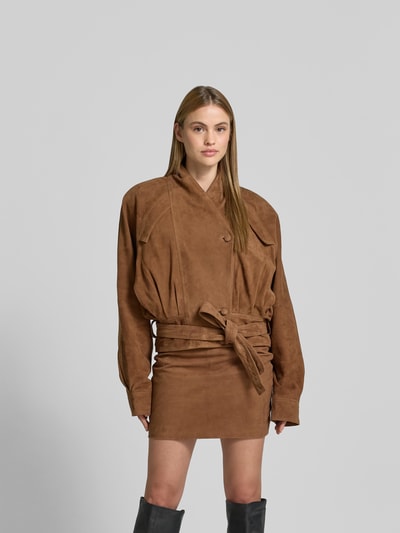 Frauenmodel trägt Lederjacke aus echtem Ziegenleder von ROTATE in Braun, Regular-Fit, Stehkragen, Brusttaschen, Knopfleiste, Ganzkörperansicht von vorne, Rückenlänge bei Größe 36: 60 cm, Brustweite bei Größe 36: 37 cm, Ärmellänge bei Größe 36: 82 cm.