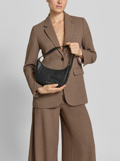 Frauenmodel trägt Shoulder Bag aus Rindsleder-Mix Modell 'Lifetime' von Hey Marly in Schwarz mit Ketten-Schulterriemen, Logo-Detail, Ganzkörperansicht von vorne.