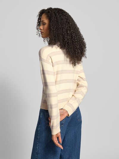 Frauenmodel trägt Regular Fit Cardigan aus Viskose-Mix Modell 'GOLD STRIPE' von Vero Moda im Two-Tone-Design mit gestreiftem Strick, Optik: unifarben, Rippen an Ärmeln und Rumpf, Label-Stitching-Applikation, Ganzkörperansicht Rückansicht.
