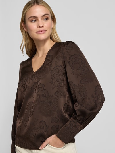 Vrouwenmodel draagt Regular Fit Langarmbluse mit V-Ausschnitt van VERO MODA, bloemen all-over patroon, V-hals, lange mouwen, manchetten, bustenahaufnahme.