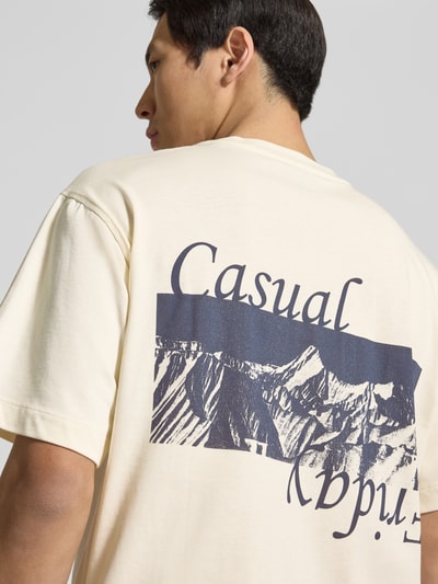 Männermodel trägt t-shirt van puur katoen model 'KARLBERG' van Casual Friday met labelstitching, labelprint, los model, ruglengte maat M 67 cm, lichte kleur met donker grafisch motief, detailaufnahme schouderpartij en rug.