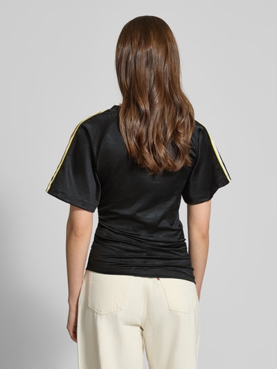 Vrouwenmodel draagt T-Shirt met V-Ausschnitt van adidas Originals in zwart met asymmetrisch design, aansluitende fit, labeldetails, korte mouwen, ruglengte 64 cm, geheelopname rugaanzicht.