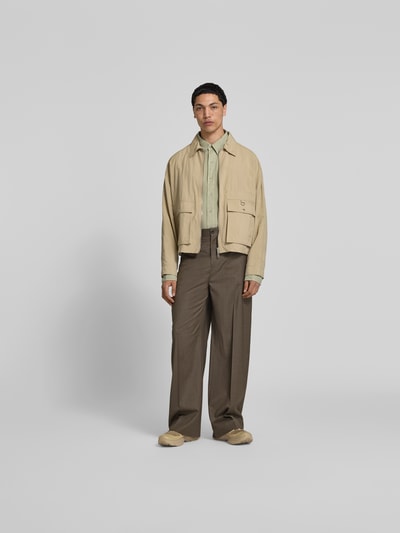 Mannelijk model draagt Wide Fit Stoffhose aus Woll-Mix van Filippa K in bruin met elastische wolmix, vouwplooien, achterzakken, knoop- en ritssluiting, binnenbeenlengte 45 cm, taillewijdte 80 cm, volledige lichaamsaanzicht van voren.