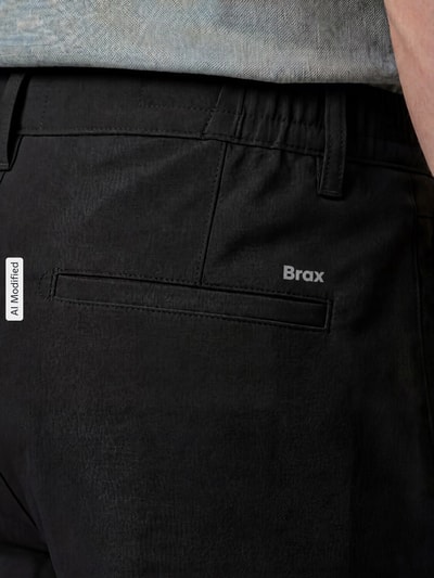 Männermodel trägt schwarze Tapered Fit Stoffhose mit Viskose-Anteil Modell 'Phil' von Brax, feine Textur, Nahaufnahme Rückansicht, Herren Gerade Hose von Brax