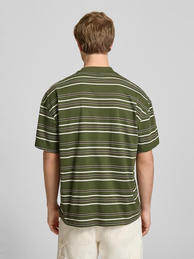 Männermodel trägt Herren T-Shirt mit Streifen in Grün und Weiß, Reine Baumwolle, Relaxed-Fit, Modell 'EAST LIBERTY' von Dickies, Logo-Stitching, Rundhalsausschnitt, Rückenlänge bei Größe M: 68 cm, Ganzkörperansicht Rückansicht.