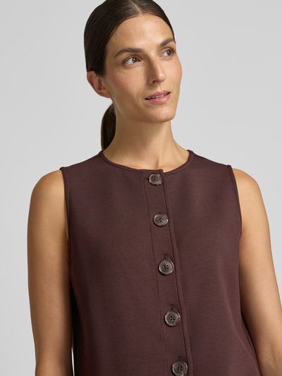 Frauenmodel trägt Regular Fit Weste aus Viskose-Mix Modell 'Josie' von VARLEY in Dunkelbraun mit Knopfleiste, Nahaufnahme Oberkörper, Damen Weste von VARLEY, elastischer Viskose-Mix, Rückenlänge bei Größe S 51 cm.