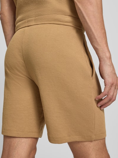 Männermodel trägt Regular Fit Sweatshorts aus Baumwoll-Mix von BOSS in Beige mit sichtbarer Struktur, Detailaufnahme Rückansicht, Herren Sweatshorts.