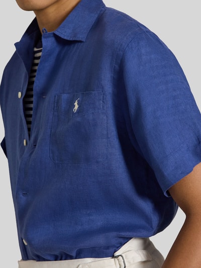 Männermodel trägt Regular Fit Freizeithemd aus reinem Leinen van Polo Ralph Lauren, effen blauw, borstzak, logo-stitching, korte mouwen, close-up bovenlichaam