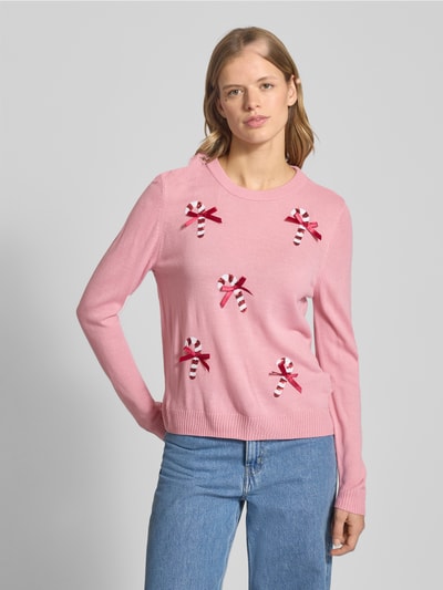 Modelka kobieca nosi Regular Fit Weihnachtspullover mit Pailletten-Motiv Modell 'XMAS SHINE' od Only, różowy sweter z cekinami, dzianinowy, unifarbny, długi rękaw, okrągły dekolt, faktura gładka, przód, ujęcie całej sylwetki z przodu.
