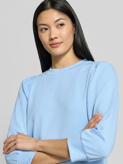 Vrouwenmodel draagt lichtblauwe pullover uit modalmix van Rich & Royal met losse pasvorm en elastische boorden, 3/4-mouw, close-up bovenlijf