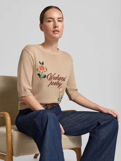 Vrouwenmodel draagt Regular fit gebreid shirt uit katoenmix model 'FIACRE' van Weekend Max Mara, beige met bloemmotief, zittend, Nahaufnahme Oberkörper.
