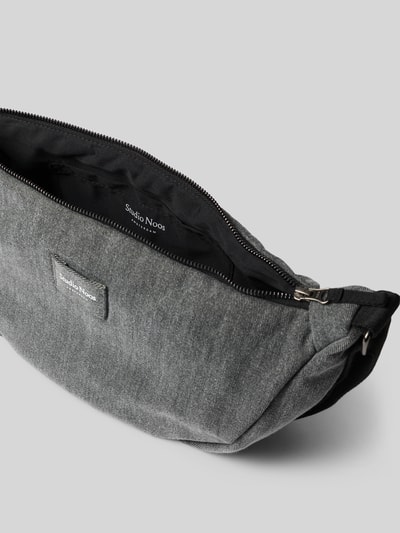 Produktfoto, Pouch aus reiner Baumwolle in Denim-Optik von Studio Noos, grau, rechteckige Form, Reißverschluss, sichtbare Stoffstruktur, Logo-Detail, verstellbarer Schulterriemen, Hauptfach, Maße 40x20x10 cm, Länge Schulterriemen 63 cm