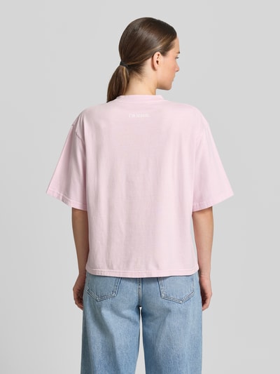 Frauenmodel trägt Boxy Fit T-Shirt aus reiner Baumwolle von Marc O'Polo in Optik: Unifarben, Passform: Boxy-Fit, Label-Schriftzug, Rundhals-Ausschnitt, Ärmelform: Kurzarm, Material: Reine Baumwolle, zartrosa, glatte Textur, Ganzkörperansicht Rückansicht.