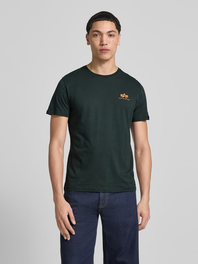 Męskimodel nosi t-shirt z bawełny, prosty krój, okrągły dekolt, Label-Details, T-Shirt mit Label-Details Modell 'BASIC' od Alpha Industries, długość tyłu w rozmiarze M: 67 cm, Ganzkörperansicht von vorne.