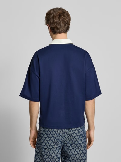 Männermodel trägt Regular Fit T-Shirt aus reiner Baumwolle von adidas Originals in Dunkelblau mit Polokragen, Rückenlänge 67 cm, Ganzkörperansicht Rückansicht.