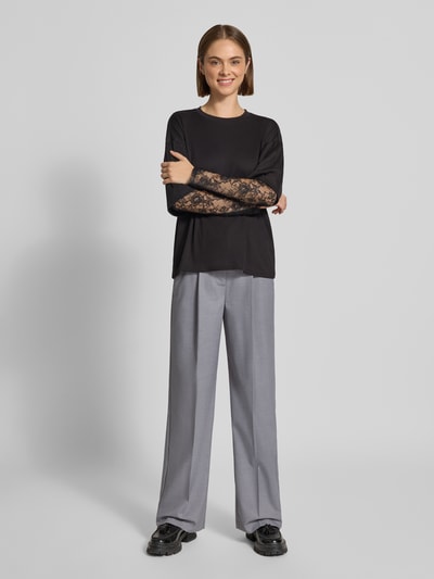 Vrouwenmodel draagt Wide Fit broek met viscose van Model 'Aya Ellis' van JJXX in lichtgrijs, elastische materiaalmix, bandplooien, persplooien, haakjes- en ritssluiting, bandwijdte maat S/32 37 cm, binnenbeenlengte S/32 77 cm, voorkant lichaamsopname.