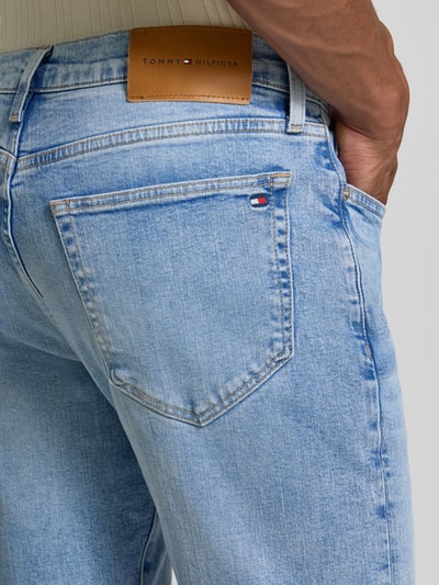 Männermodel trägt Slim Fit Straight Jeans aus katoenmix Modell 'DENTON' van Tommy Hilfiger, lichte blauwe wassing, detailopname achterkant, heren straight jeans van Tommy Hilfiger.
