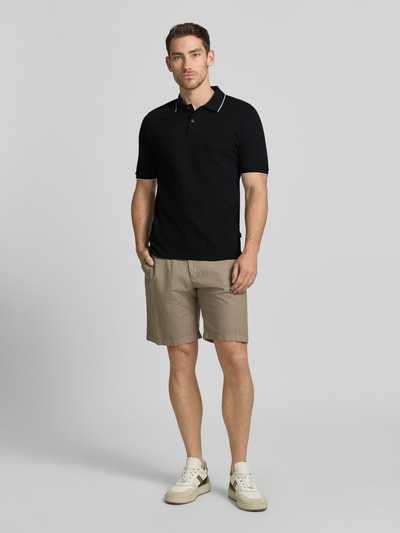 Mężczyznamodel nosi Slim Fit Poloshirt mit Stitching von Jack & Jones Premium z bawełny, krój slim fit, haft, listwa guzikowa, długość tyłu 70 cm w rozmiarze M, widok całej sylwetki od przodu.