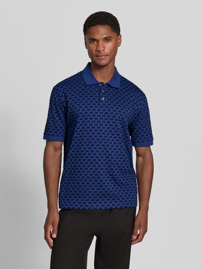 Männermodel trägt Regular Fit Poloshirt aus reiner Baumwolle von Armani Exchange, Allover-Logo-Print, blau, Ganzkörperansicht von vorne.