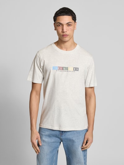 Männermodel trägt Herren T-Shirt aus Bio-Baumwolle Modell 'NANTUCKET' von Jack & Jones mit Label-Print, gerader Schnitt, Rundhalsausschnitt, Rückenlänge bei Größe M: 68 cm, helle Farbe, glatte Textur, Ganzkörperansicht von vorne.