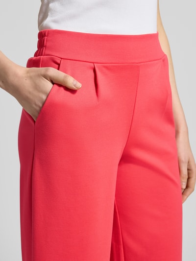 Frauenmodel trägt Wide Fit Hose mit elastischem Bund Modell 'Kate' von ICHI in kräftigem Pink, Material-Mix mit Viskose-Anteil, Nahaufnahme Oberkörper. Bundweite bei Größe S: 37 cm, Innenbeinlänge bei Größe S: 66 cm.