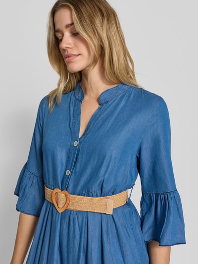 Frauenmodel trägt Jeanskleid mit Gürtel und Rüschenärmel Modell 'Li44yanaa' von ZABAIONE aus Lyocell, blaue Textur, Nahaufnahme Oberkörper.