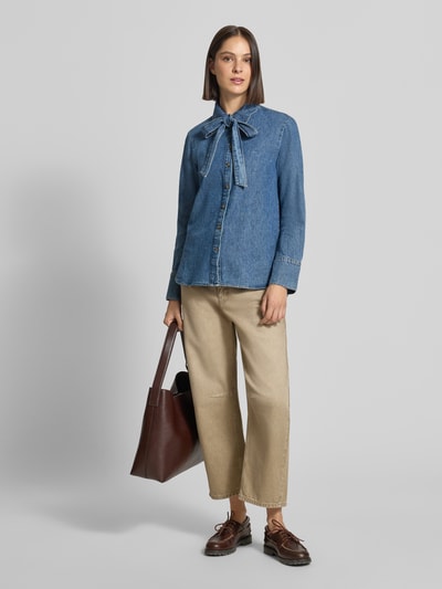 Modelka nosi Relaxed Fit Hemdbluse aus reiner Baumwolle in Denim-Optik von zero, tkanina stylizowana na denim, ozdobna kokarda, z długim rękawem, kołnierzyk koszulowy, widoczna cała sylwetka z przodu.