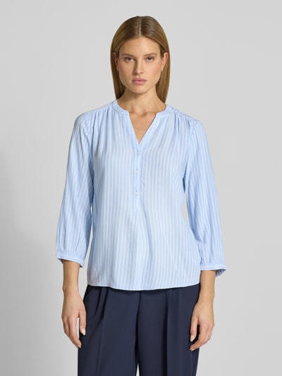 Kobiece model nosi Comfort Fit Langarmbluse aus reiner Viskose od Tom Tailor, efekt: wzór na całej powierzchni, krój comfort fit, kształt kołnierza: stójka, dekolt: tunika, zapięcie: krótka listwa guzikowa, rękaw: rękaw o dł. 3/4, zakończenie rękawów: mankiet, materiał: czysta wiskoza, jasnoniebieskie paski, tekstura lekka, całkowity widok z przodu