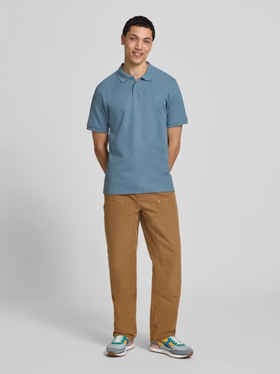 Männermodel trägt Regular Fit Poloshirt mit Strukturmuster Modell 'AUSTIN' von Jack & Jones, Baumwoll-Mix, Knopfleiste, Ganzkörperansicht von vorne.