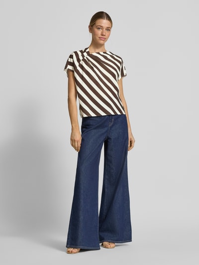 Vrouwenmodel draagt Blusenshirt aus Viskose-Mix mit asymmetrischem Ausschnitt van Windsor, loose fit, beige met bruine strepen, voorkant geheel zichtbaar, lengte rug maat 36: 56 cm. Ganzkörperansicht von vorne.