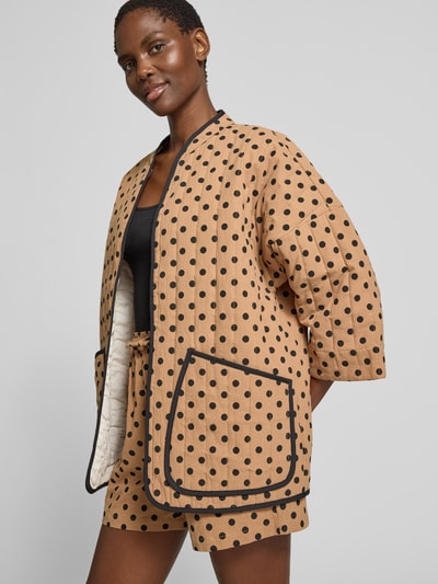Frauenmodel trägt Jacke im Allover-Look Modell 'Lulu' von LOLLYS LAUNDRY, Reine Baumwolle, Relaxed-Fit, beige mit schwarzen Punkten, 3/4-Arm, Ganzkörperansicht von vorne. Rückenlänge 73 cm, Schulterbreite 42 cm, Brustweite 62 cm, Ärmellänge 45 cm.
