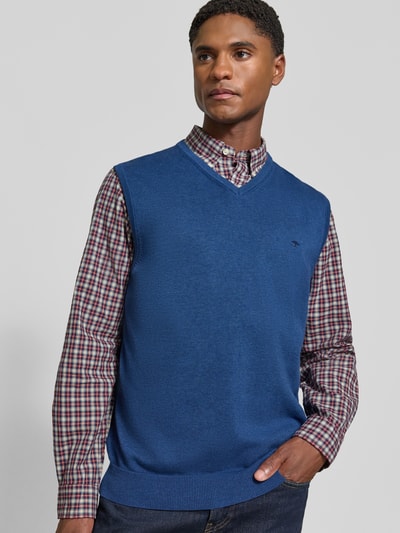 Männermodel trägt Regular Fit Pullunder aus reiner Baumwolle mit Logo-Stickerei von Fynch-Hatton in Blau und gerippten Bündchen, Ganzkörperansicht von vorne.
