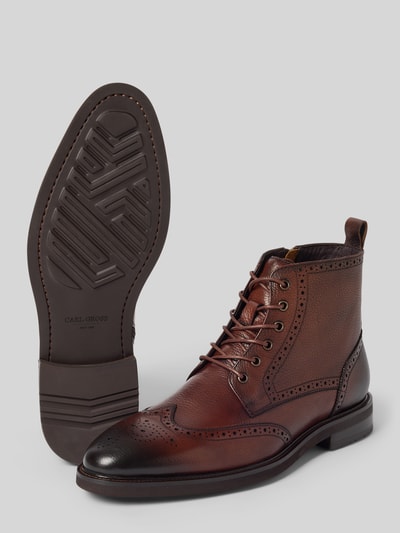 Produktfoto, botki sznurowane z naturalnej skóry Carl Gross Schnürboots aus echtem Leder Modell 'UDET', zaokrąglony kształt, perforowanie, gładka podeszwa, obcas męski o wysokości 3 cm w rozmiarze 44, wysokość cholewki 13 cm, szerokość w rozmiarze 44: 10 cm, wiązanie, kolor brązowy z ciemniejszymi akcentami, różne faktury skóry, wyraźna struktura.