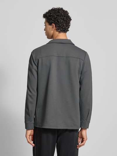 Männermodel trägt Regular Fit Hemdjacke mit Viskose-Anteil Modell 'NEWKODYL' von Only & Sons in unifarbenem Twill, Ganzkörperansicht Rückansicht.