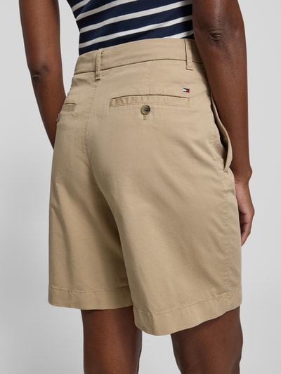 Frauenmodel trägt Regular Fit Chino-Shorts aus Baumwoll-Lyocell-Mix von Tommy Hilfiger, Optik: Unifarben, Logo-Stitching, Gesäßtaschen, Ganzkörperansicht Rückansicht.