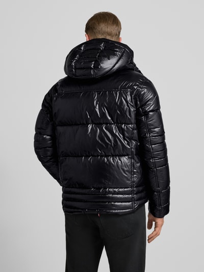 Männermodel trägt Regular Fit Steppjacke mit Kapuze von Tom Tailor, Optik: Unifarben, Applikation: Label Patch, Ganzkörperansicht Rückansicht.