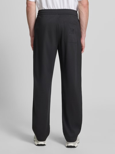 Männermodel trägt Sweatpants mit elastischem Bund von Emporio Armani aus Lyocell-Mix mit Viskose-Anteil, Relaxed-Fit und Eingrifftaschen, Ganzkörperansicht Rückansicht.