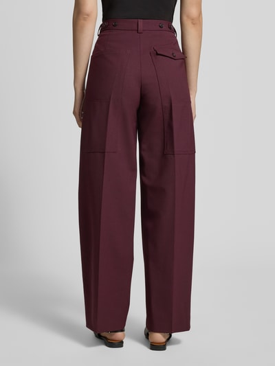 Vrouwenmodel draagt Loose Fit Weite Hose aus Woll-Mix van Tommy Hilfiger in effen bordeauxrood met logodetail, twillstructuur, persvouwen, riemlussen, knoop- en ritssluiting, steekzakken en klepzakje, achterkant volledig zichtbaar, Ganzkörperansicht Rückansicht.