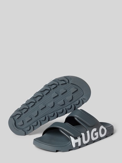 Produktfoto, Sandale mit Logo Print von HUGO w dwukolorowy, zaokrąglony nosek buta, płaska podeszwa, nadruk z logo, dwa paski z rzepem