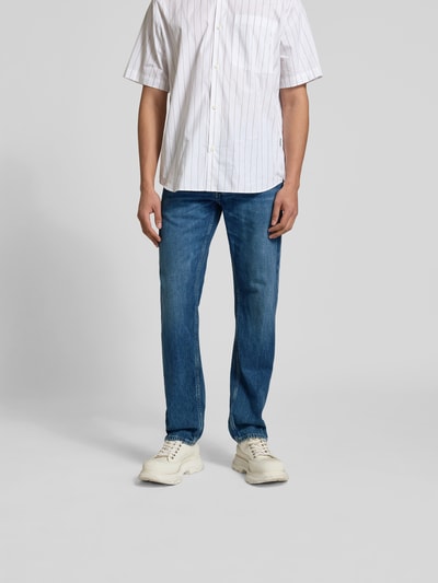 Männermodel trägt Straight Fit Jeans mit Logo-Patch von Closed aus reiner Baumwolle, 5-Pocket-Design, blaue Farbe, Ganzkörperansicht von vorne.